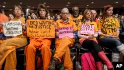 Activists from the antiwar group CodePink hold a silent protest at the Senate Armed Services Committee during a hearing in Washington on the fate of the Guantanamo Bay detention center, Feb. 5, 2015.