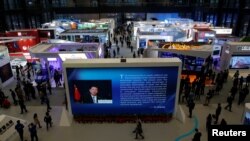 FILE - China's President Xi Jinping is shown on a screen in front of logos of China's leading internet companies during the World Internet Conference in Wuzhen town of Jiaxing, Zhejiang province, China, Nov. 17, 2016. (REUTERS/Aly Song)