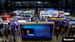 FILE - China's President Xi Jinping is shown on a screen in front of logos of China's leading internet companies during the World Internet Conference in Wuzhen town of Jiaxing, Zhejiang province, China, Nov. 17, 2016.