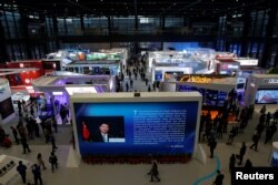 FILE - China's President Xi Jinping is shown on a screen in front of logos of China's leading internet companies during the World Internet Conference in Wuzhen town of Jiaxing, Zhejiang province, China, Nov. 17, 2016.
