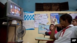 Para pelajar menonton siaran langsung pidato Presiden Kuba Raul Castro mengenai restorasi hubungan dengan Amerika Serikat, dari televisi di sekolah di Havana (17/12). (AP/Ramon Espinosa)