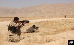 FILE - Afghan security forces clash with Taliban fighters on the highway connecting Balkh province to Kunduz city, north of Kabul, Afghanistan, Sept. 1, 2015.