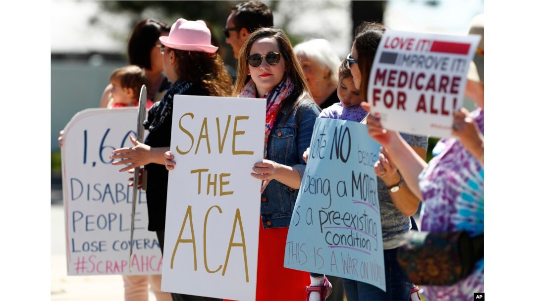 Larissa Pisney, center, of Denver joins a line of people during a protest outside the Aurora, Colo., office of Republican U.S. Rep. Mike Coffman over the health care overhaul bill that was voted on in the U.S. House, May 4, 2017.