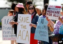 FILE - Supporters of the Affordable Care Act gather in Aurora, Colorado, during a protest of the health care overhaul bill that was voted on in the U.S. House, May 4, 2017.