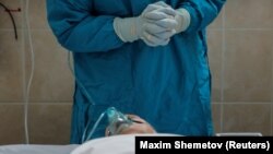 Arhiva, ilustracija: Zdravrstveni radnik u zaštitnoj odeći stoji nad pacijengtom obolelim od koronavirusa, u Gradskoj bolnici 52, u Moskvi, Rusija, 8. oktobra 2020. (REUTERS/Maxim Shemetov )