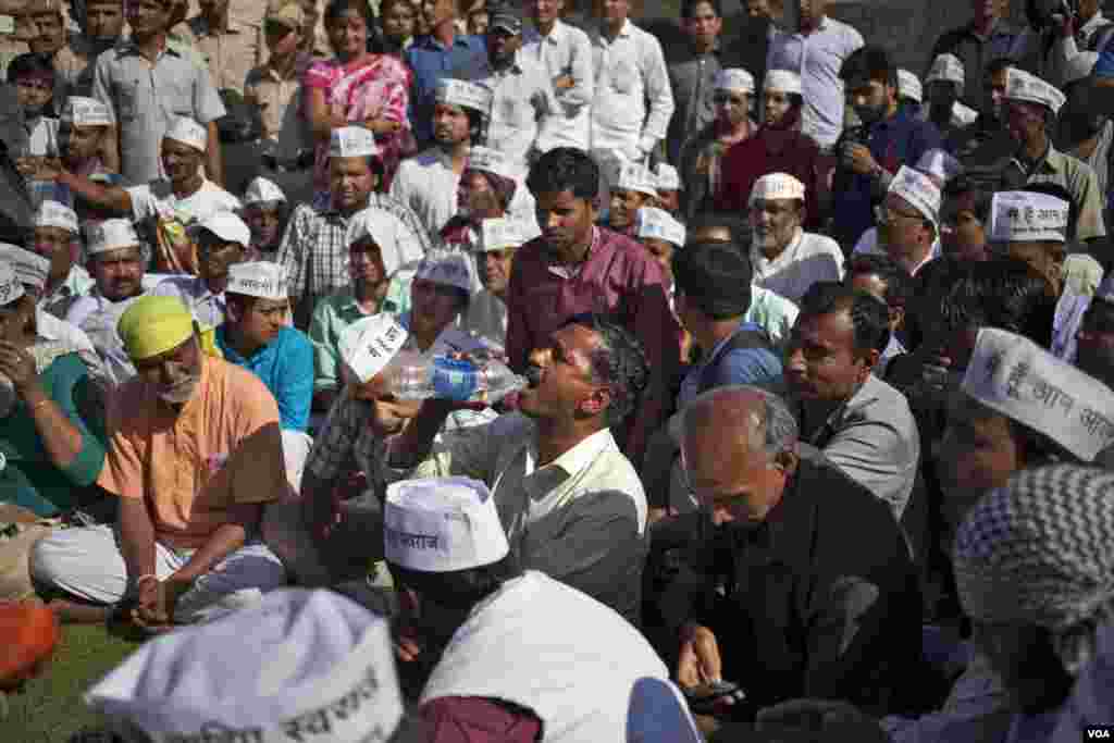 Ketua Partai Aam Aadmi Arvind Kejriwal minum sambil duduk di Rajghat, tempat penghormatan untuk Mahatma Gandhi, setelah ditampar penyerang dalam sebuah kampanye di New Delhi (8/4). (AP/Tsering Topgyal)