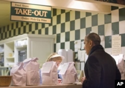 President Barack Obama stops at the counter to place his order during an unscheduled visit to the Feed Store, a sandwich shop in Springfield, Ill., Feb. 10, 2016.