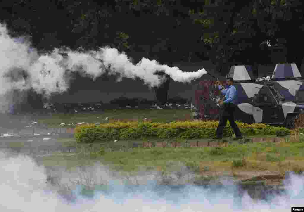 A policeman fires tear gas to disperse demonstrators during the Revolution March towards the prime minister&#39;s house in Islamabad, Sept. 1, 2014.