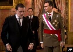 FILE - Spain's King Felipe VI walks with Spain's Prime Minister Mariano Rajoy, left, during the annual Pascua Militar Epiphany ceremony at the Royal Palace in Madrid, Spain, Jan. 6, 2016. Spain's king is meeting Tuesday with the country's political parties.