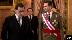 FILE - Spain's King Felipe VI walks with Spain's Prime Minister Mariano Rajoy, left, during the annual Pascua Militar Epiphany ceremony at the Royal Palace in Madrid, Spain.