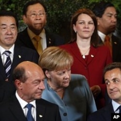 German Chancellor Angela Merkel, center, speaks with French President Nicolas Sarkozy, front right, and Romania's President Traian Basescu, front left, during a group photo at an ASEM 8 summit in Brussels (File Photo)