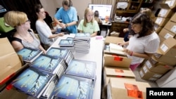 Para pegawai toko buku Ol' Curiosities & Book Shoppe di Monroeville, Alabama, mengeluarkan buku-buku "Go Set A Watchman" dari dalam kardus (14/7). 