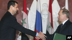 Syrian President Bashar Assad and Russian President Vladimir Putin shake hands during ceremony, the Kremlin, Jan. 2005 (file photo).