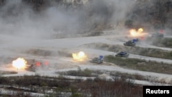 FILE - South Korean Army K1A1 and U.S. Army M1A2 tanks fire live rounds during a U.S.-South Korea joint live-fire military exercise, at a training field near the demilitarized zone separating the two Koreas in Pocheon, South Korea, April 21, 2017.