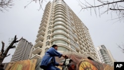 一男子骑车经过中国上海某处刚建好的居民楼