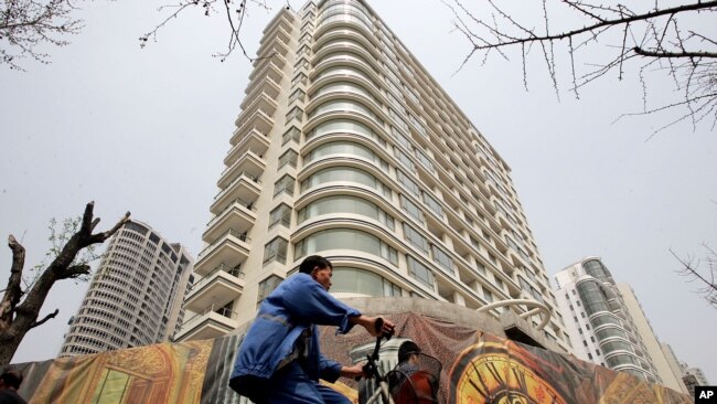 一男子骑车经过中国上海某处刚建好的居民楼