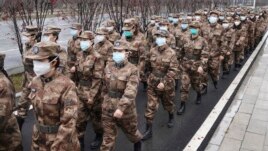 In this Jan. 26, 2020, photo released by Xinhua News Agency, members of a military medical team head for Wuhan Jinyintan Hospital in Wuhan, central China's Hubei province. (Cheng Min/Xinhua via AP)