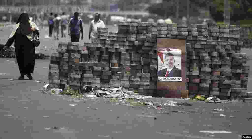 Members of the Muslim Brotherhood and supporters of deposed Egyptian president Mohamed Morsi walk around makeshift barricades near Cairo&#39;s Rabaa el-Adawiya Square, July 28, 2013.