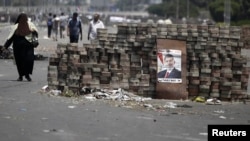 Members of the Muslim Brotherhood and supporters of deposed Egyptian president Mohamed Morsi walk around makeshift barricades near Cairo's Rabaa el-Adawiya Square July 28, 2013.