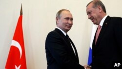 Russian President Vladimir Putin, left, welcomes Turkish President Recep Tayyip Erdogan in the Konstantin palace outside St.Petersburg, Russia, on Aug. 9, 2016. 
