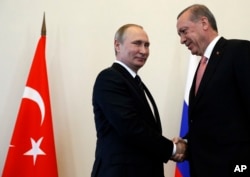 ປະທານາທິບໍດີ ຣັດເຊຍ ທ່ານ Vladimir Putin, ຊ້າຍ, ຕ້ອນຮັບປະທານາທິບໍດີ ເທີກີ ທ່ານ Recep Tayyip Erdogan ໃນທຳນຽບ Konstantin ຢູ່ນອກນະຄອນ St. Petersburg. ຣັດເຊຍ. 9 ສິງຫາ, 2016.