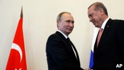 Russian President Vladimir Putin, left, welcomes Turkish President Recep Tayyip Erdogan in the Konstantin palace outside St.Petersburg, Russia, on Aug. 9, 2016. 