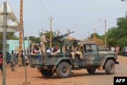 Malian soldiers ride on a pick-up truck with a machine gun after a suicide car bomb attack overnight in Gao, Nov. 13, 2018.