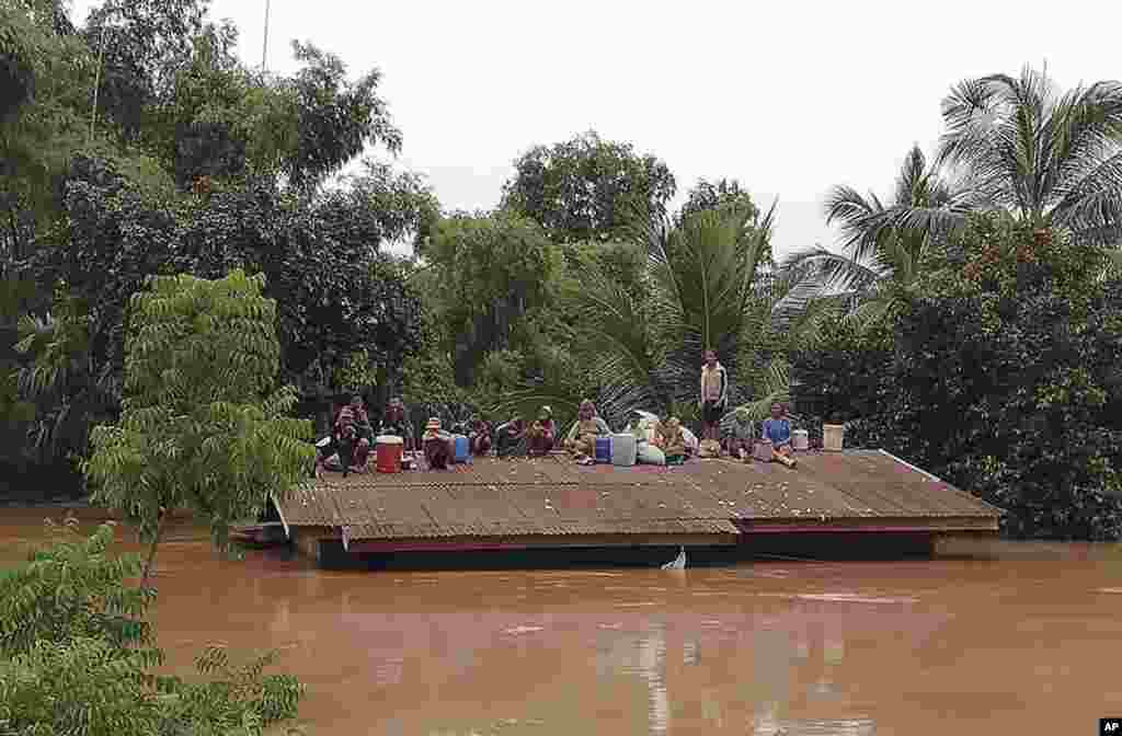 라오스 남동부&nbsp;아타프 주에서 수력발전댐이 붕괴된 후 주민들이 물에 잠긴 지붕 위로 대피해 구조를 기다리고 있다.