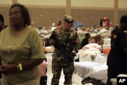 FILE - After Hurricane Katrina, an armed National Guard soldier patrols a Red Cross shelter in Baton Rouge, Louisiana, Oct. 4, 2005.