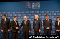 U.S. Vice President Mike Pence, center left, shakes hands with Macedonia's Prime Minister Zoran Zaev, next to Montenegrin Prime Minister Dusko Markovic, third right, as they pose for a family photo during the Adriatic Charter Summit in Podgorica, Montenegro, Aug. 2, 2017.