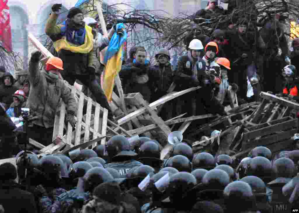 Anti-Yanukovych protesters defend their barricades against riot police on Independence Square in Kyiv, Ukraine.