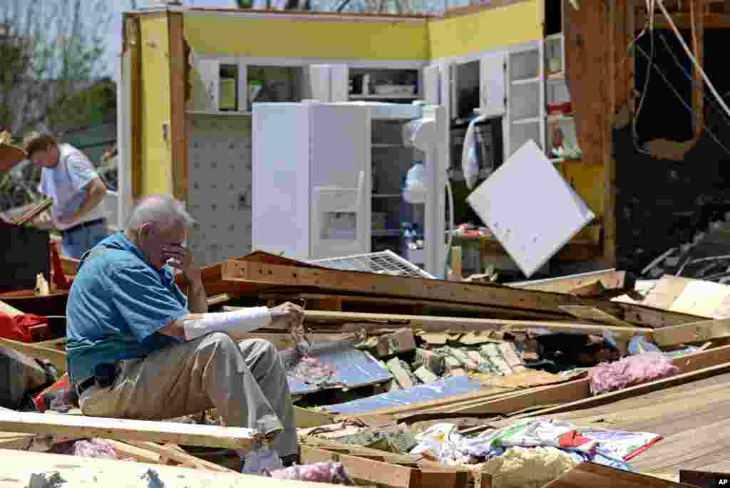 Charles Milam takes a break while searching his destroyed home on Clayton Avenue in Tupelo, Mississippi, USA, April 29, 2014. Milam, his wife and his granddaughter were at home at the time of the tornado, and all survived.