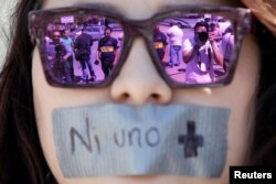 Journalists are reflected on sunglasses of a woman during a protest against the murder of the Mexican journalist Miroslava Breach, outside the Attorney General's Office (PGR) in Ciudad Juarez, Mexico March 25, 2017.