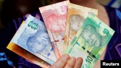 Photo d'archives: Le Gouverneur de la banque centrale sud-africaine tenant de nouveaux billets de banque, 6 novembre 2012 - REUTERS/Siphiwe Sibeko 