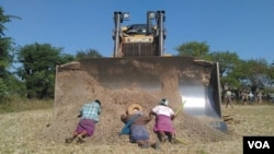 Villagers in northern Myanmar lay in front of a bulldozer as part of their bid to stop the controversial expansion of the Chinese-run Letpadaung copper mine, Dec. 22, 2014. (photographer unknown)