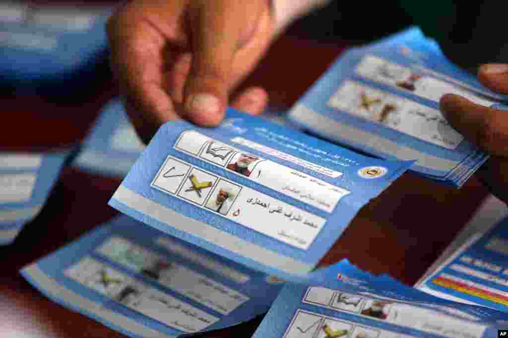 An Afghan election commission worker sorts ballots for an audit of the presidential run-off at an election commission office in Kabul, Aug. 25, 2014.