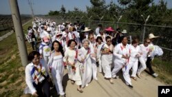 U.S. activist Gloria Steinem, seventh from right, two Nobel Peace Prize laureates and other activists march to the Imjingak Pavilion along the military wire fences near the border village of Panmunjom in Paju, north of Seoul, South Korea, May 24, 2015.
