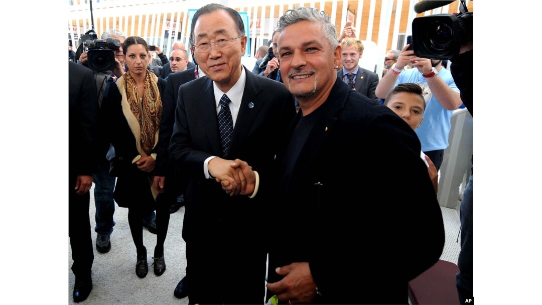 United Nations Secretary-General Ban Ki-moon, left, shakes hands with Italian soccer legend Roberto Baggio, at the Expo World's Fair on the occasion of the UN World Food Day in Rho, near Milan, Italy, Friday, Oct. 16, 2015.
