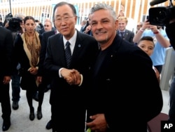 United Nations Secretary-General Ban Ki-moon, left, shakes hands with Italian soccer legend Roberto Baggio, at the Expo World's Fair on the occasion of the UN World Food Day in Rho, near Milan, Italy, Friday, Oct. 16, 2015.