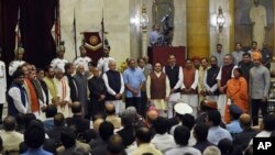 Indian President Pranab Mukherjee, eleventh from left, poses for photographs with Prime Minister Narendra Modi, twelfth left, Vice President Hamid Ansari, tenth left and the newly sworn in ministers at the presidential palace in New Delhi, India, Sunday, 