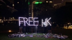香港民眾11月9日晚在添馬公園舉行集會，悼念不幸去世的香港科技大學學生週梓樂。活動結束後，有民眾撐起Free HK（自由香港）字樣的燈光。（美國之音林楓拍攝）