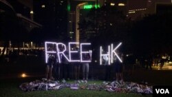 香港民眾11月9日晚在添馬公園舉行集會，悼念不幸去世的香港科技大學學生周梓樂。活動結束後，有民眾撐起Free HK（自由香港）字樣的燈光。（美國之音林楓拍攝）