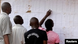 Des électeurs regardent les noms sur un mur au bureau de vote de Kisumu, Kenya, le 6 août 2017.