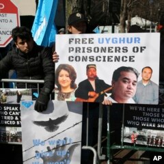 Protestors hold up signs to raise awareness about the treatment of Uyghurs in northwest China.
