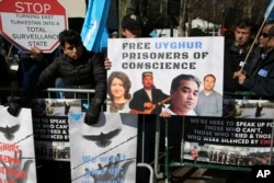 FILE - Uighurs and their supporters rally across the street from United Nations headquarters in New York, March 15, 2018. Members of the Uighur Muslim ethnic group are calling on China to post videos of their relatives who have disappeared into a vast system of internment camps. The campaign follows the release of a state media video showing famed Uighur musician Abdurehim Heyit, who many believed had died in custody.