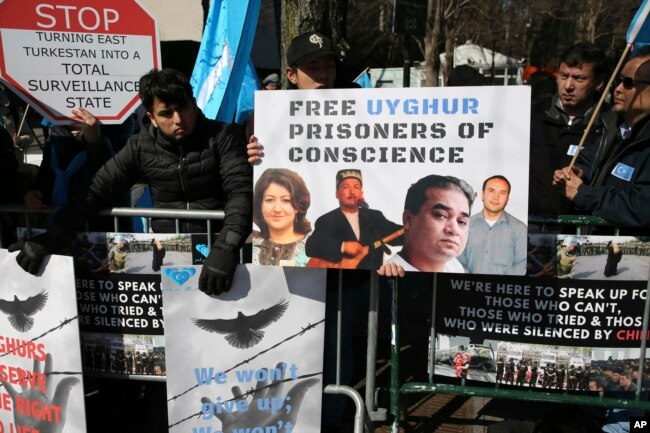 FILE - Uighurs and their supporters rally across the street from United Nations headquarters in New York, March 15, 2018.