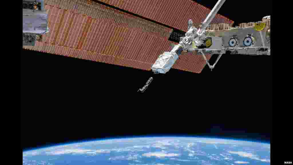 The Small Satellite Orbital Deployer (SSOD), in the grasp of the Kibo laboratory robotic arm, is photographed by an Expedition 38 crew member on the International Space Station as it deploys a set of NanoRacks CubeSats.