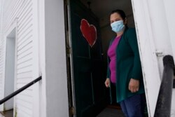 Maria Macario berdiri di pintu depan Gereja First Parish, di Bedford, Massachussets, 27 Januari 2021. (Foto: Associated Press)