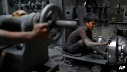 FILE - Nizam, 11, works at a factory that makes metal utensils in Dhaka, Bangladesh, June 12, 2016. 