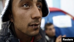 FILE - Yosri Adjili, 25, who is unemployed, goes on a hunger strike with his mouth sewed shut during a sit-in protest to get jobs, at the local government office courtyard in Kasserine, Tunisia, Jan. 27, 2016. 